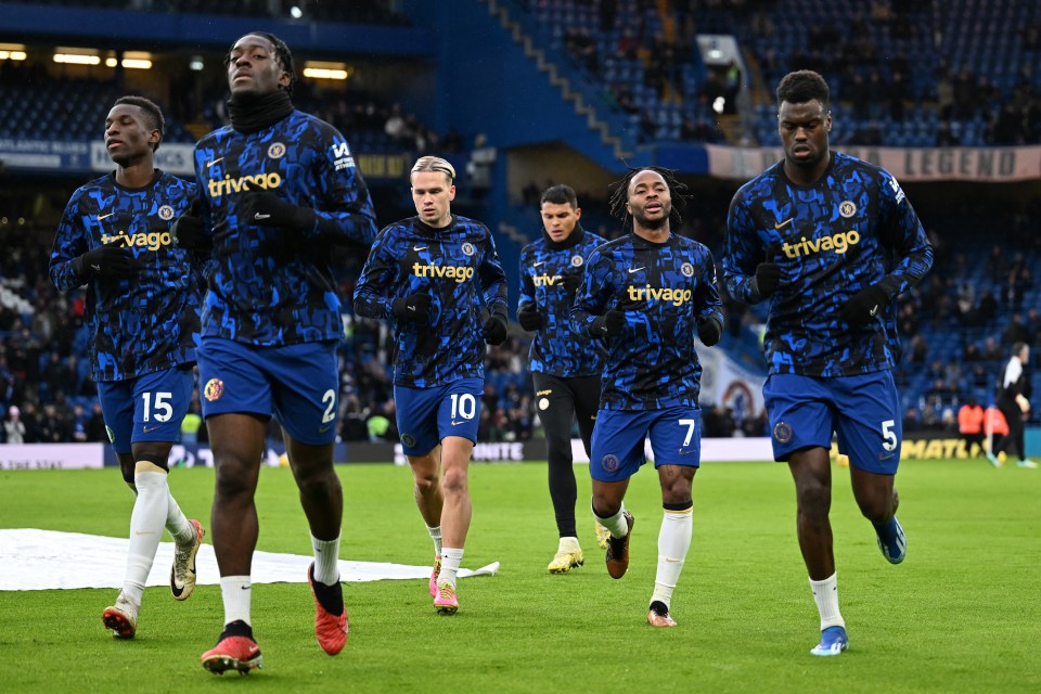 Chelsea F.C. players warming up on the field.
