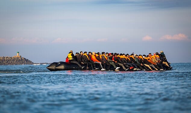 Migrants sit on an inflatable boat during an attempt to cross the English Channel, off the beach of Gravelines, northern France, 27 September 2025