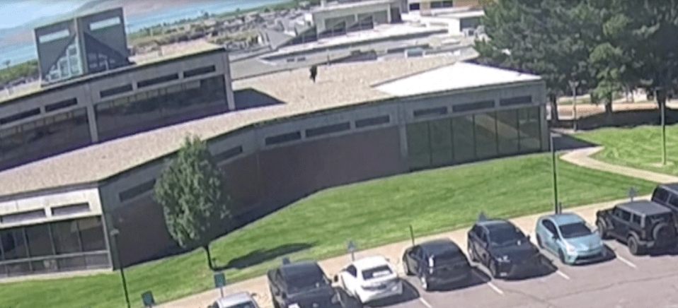 Aerial view of a building with cars parked in front.