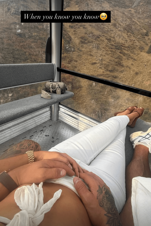 Couple holding hands in a cable car.