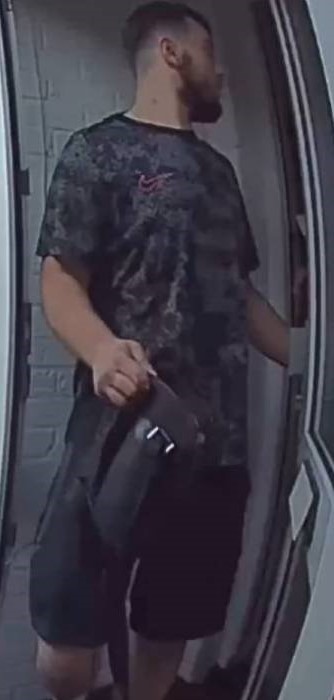 Man entering doorway carrying bag.