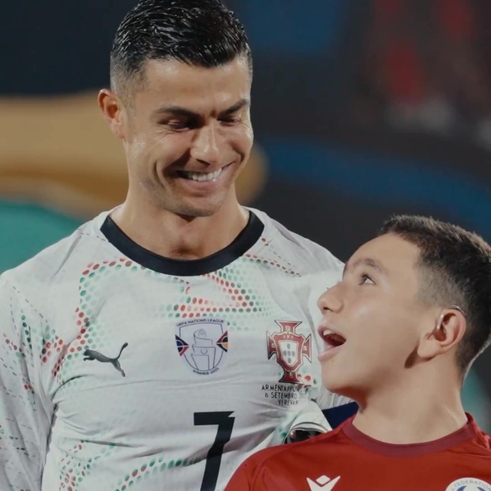 Cristiano Ronaldo consoles a young mascot.