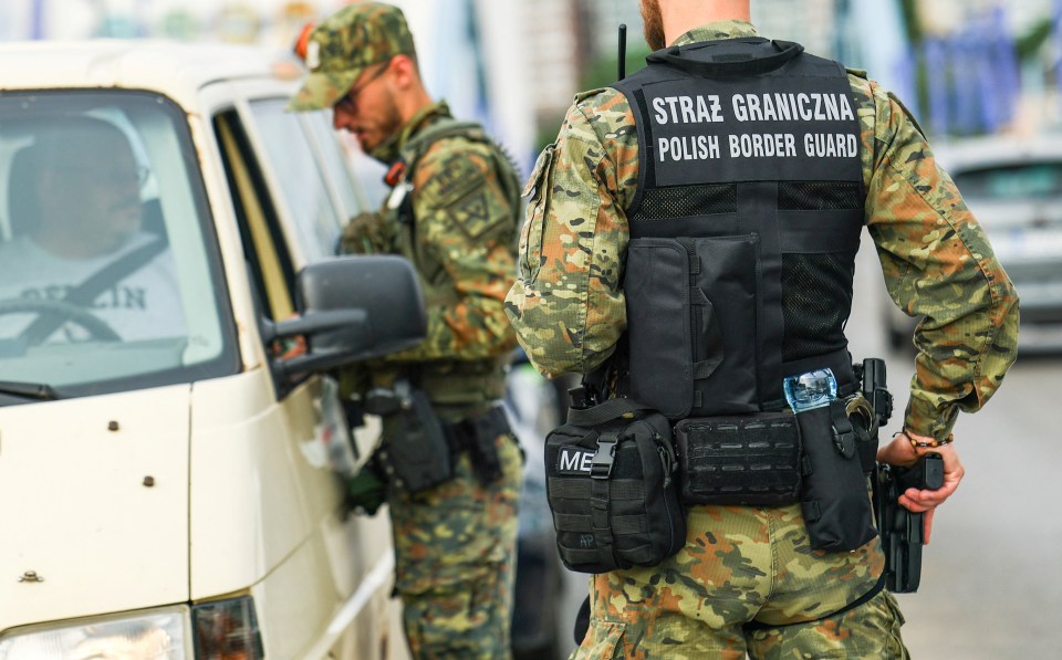 Polish Border Guard officers checking a vehicle.