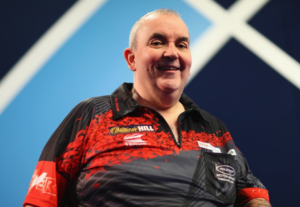 Phil Taylor of England poses for a photograph in his darts shirt.