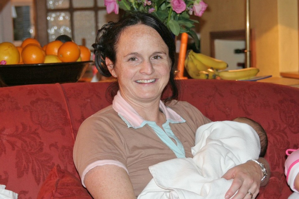 Photo of Samantha Young holding a baby.