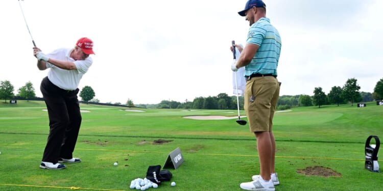 Donald Trump talks with Team Captain Bryson DeChambeau of Crushers GC on the practice range during the pro-am prior to the LIV Golf Invitational - Bedminster at Trump National Golf Club Bedminster in Bedminster, New Jersey, on July 28, 2022.