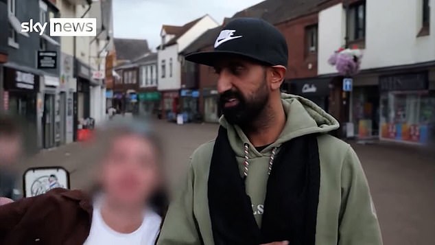 Local business owner Zahin, 32, is being interviewed by Sky News when he is interrupted by a woman holding a glass of beer