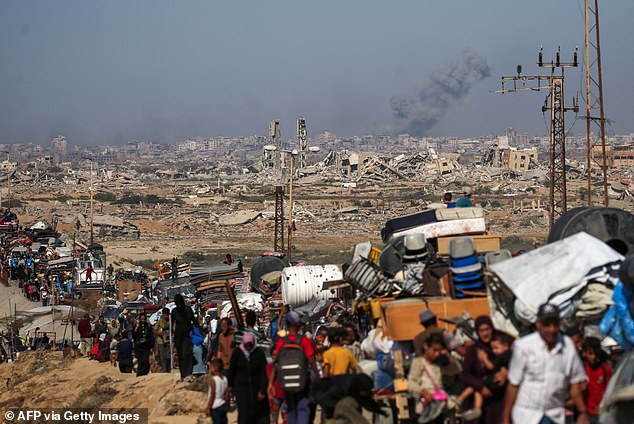 Displaced Palestinians move with their belongings southwards on a road in the Nuseirat refugee camp in the central Gaza Stri