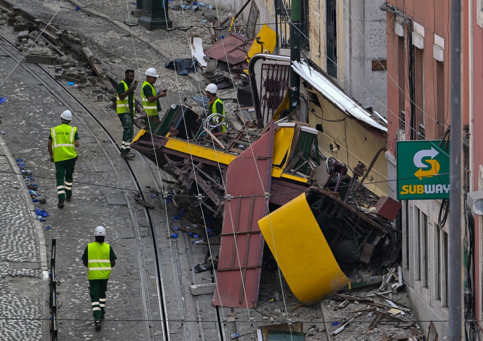 Debris of a derailed funicular in Lisbon, Portugal, with workers on site.