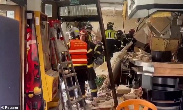 At least 25 people have been injured in a huge gas explosion at a bar in Madrid. Pictured: Emergency responders at the scene