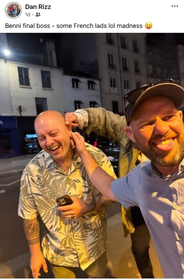 Daniel Ashley-Laws having his ear pulled by an unseen person while another man with a cap and sunglasses smiles and sticks out his tongue.