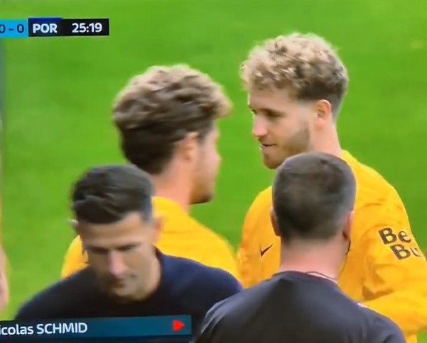 Soccer players conversing on the field.