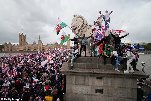 Protesters wave Union Jack and St George's England flags during the "Unite The Kingdom" rally on Westminster Bride by the Houses of Parliament