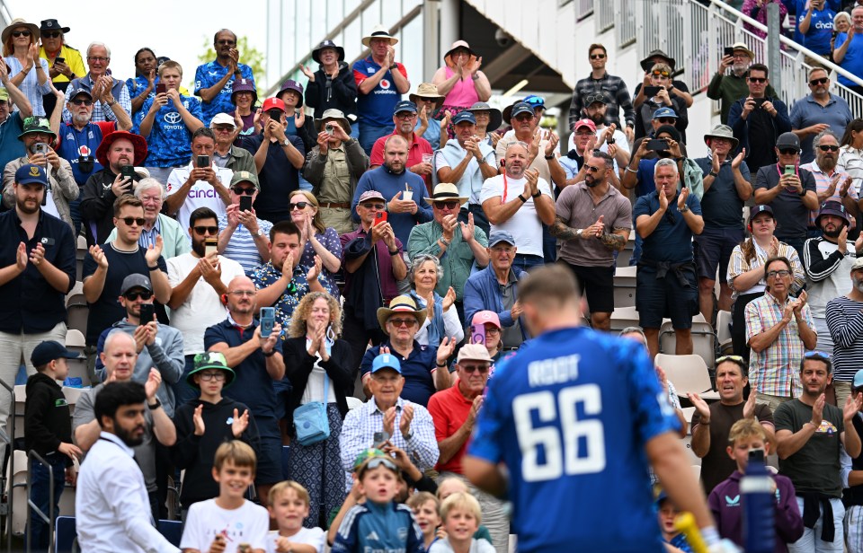 Spectators applaud Joe Root after he scores a century.