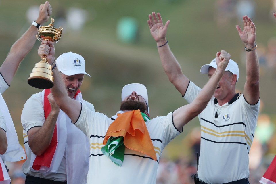 Shane Lowry celebrates with the Ryder Cup trophy and his teammates.