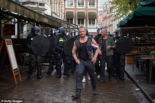 Anti-riot police officers move in to clear the city center of far-right protesters