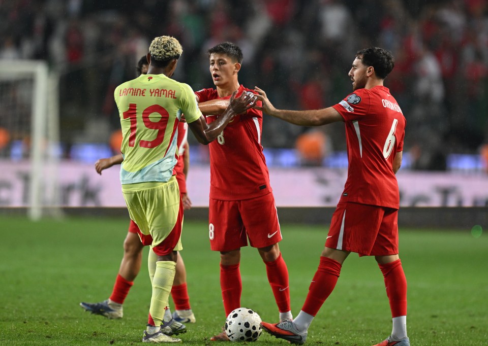 Soccer players Lamine Yamal and Arda Guler arguing on the field.