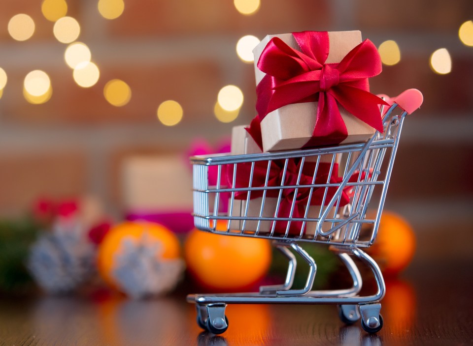 Shopping cart filled with gifts against a bokeh background.