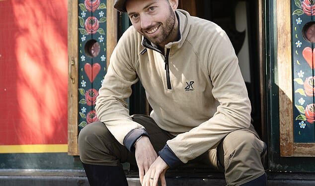 Content: Lind sat in the doorway of his narrowboat