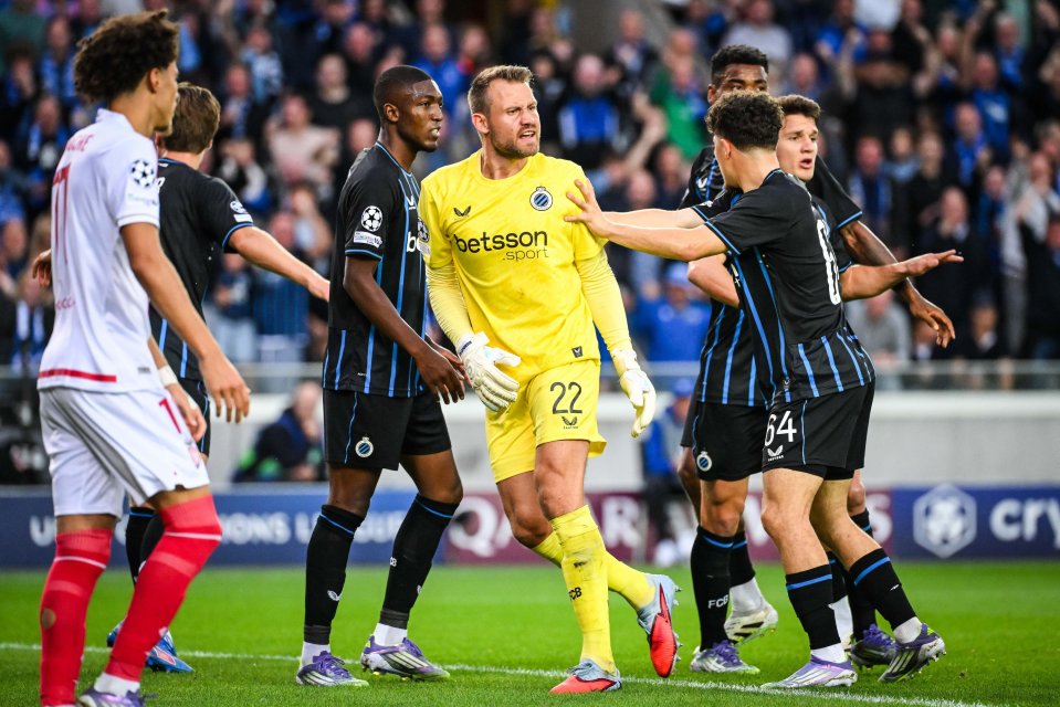 Simon Mignolet of Brugge celebrates his penalty stop with teammates during a UEFA Champions League match.