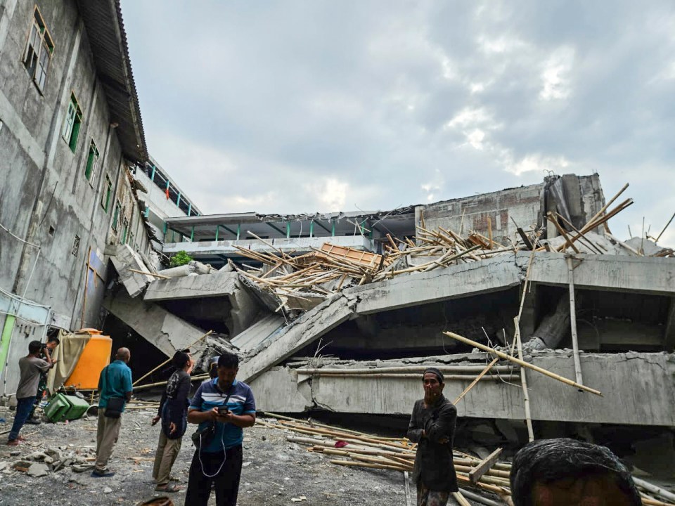Rescuers inspect a collapsed prayer building at an Islamic boarding school in Sidoarjo, East Java, Indonesia.