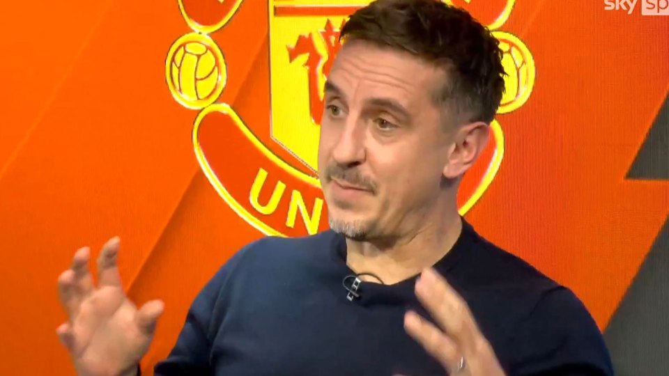 Gary Neville speaking in front of a Manchester United logo.