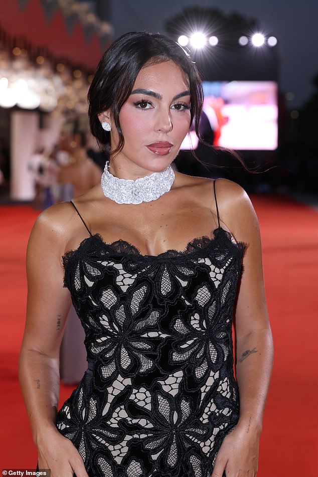 Georgina accessorised with a chunky sparkling choker necklace and opted for a pair of diamond stud earrings