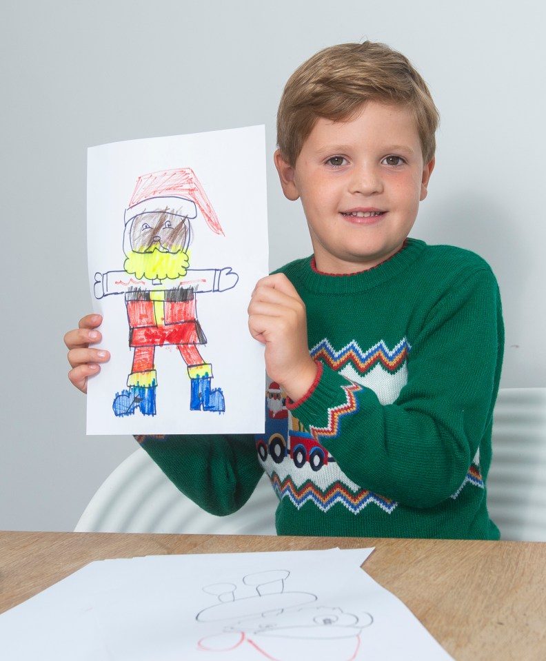 Boy holding a child's drawing of Santa Claus.