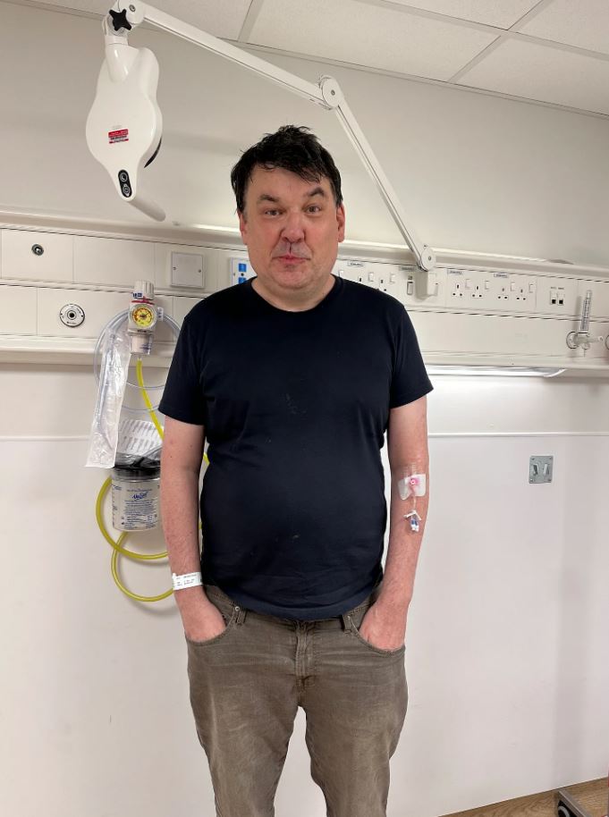 Man in hospital room with IV.