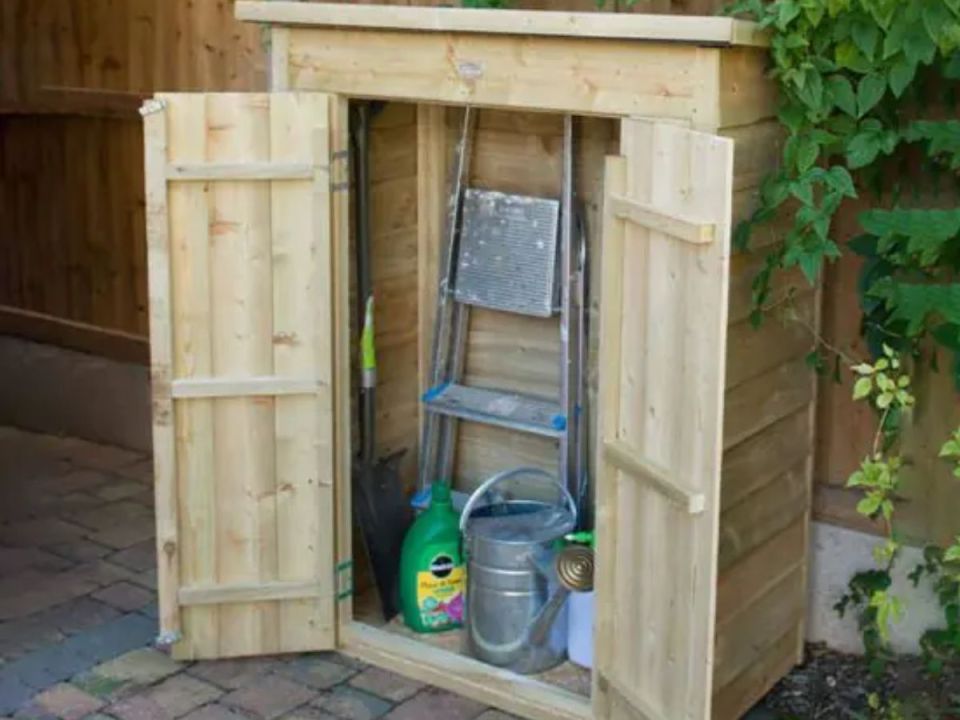 Wooden storage shed with open doors, containing gardening tools and supplies.