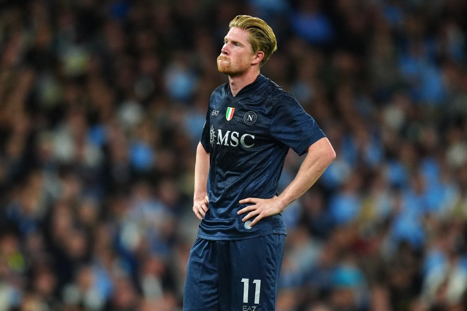 Kevin De Bruyne in a dark blue Napoli jersey looking frustrated.