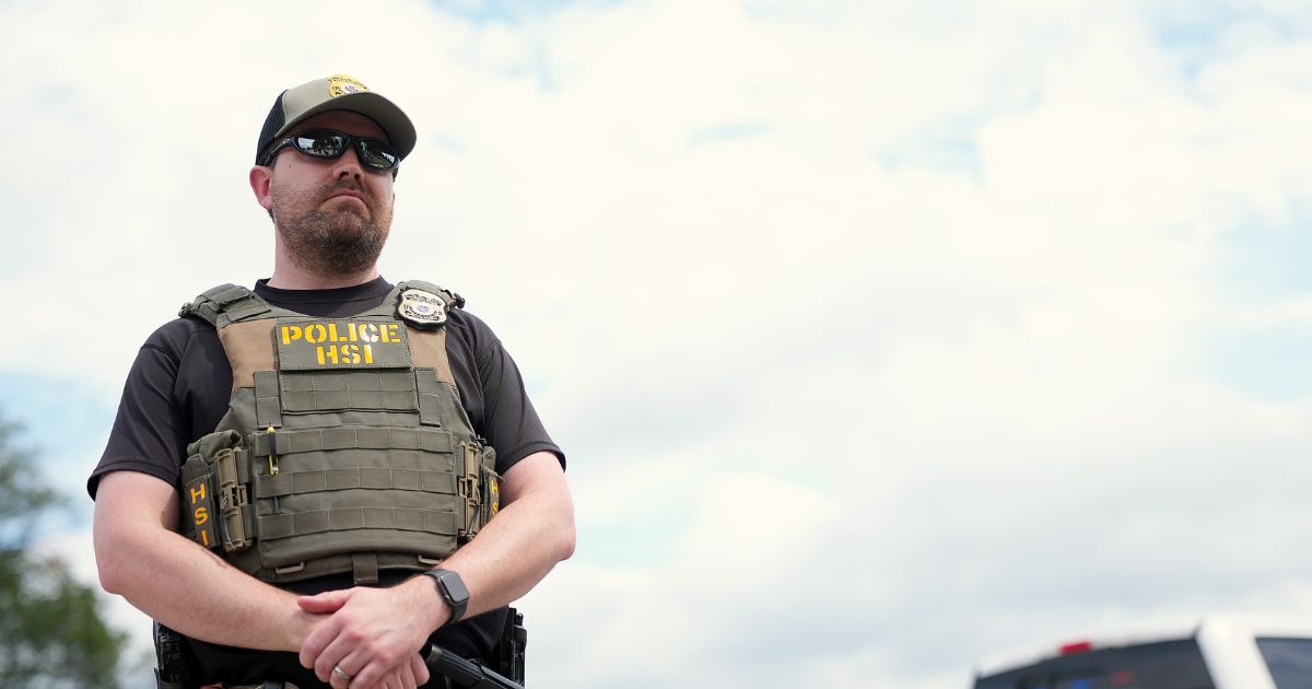 A Homeland Security Investigations officer, the investigative arm of the U.S. Department of Homeland Security, stands by as the U.S. Park Police inspect a vendor's truck after detaining a person on the National Mall on Aug. 13, 2025, in Washington, D.C.