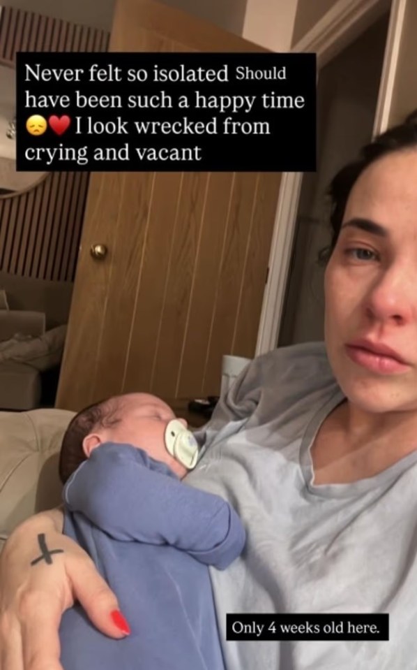 A tired-looking mother holding her newborn baby, expressing feelings of isolation.