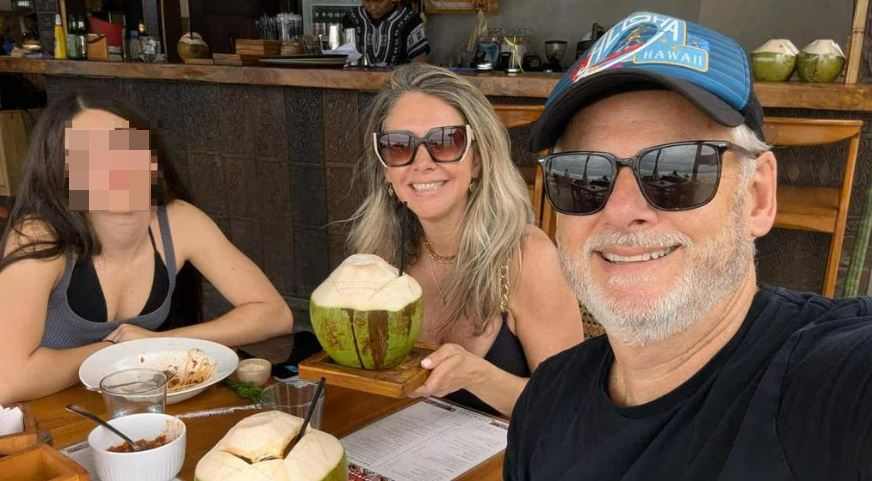 Flavia McDonald, her husband, and their daughter Lorena enjoying a meal with fresh coconut drinks.
