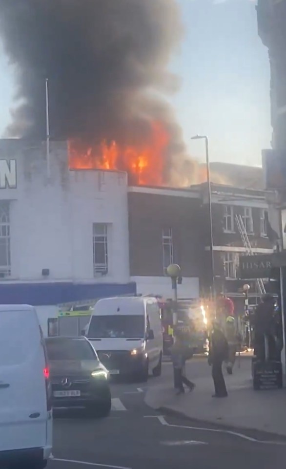 Building on fire with smoke billowing into the sky.