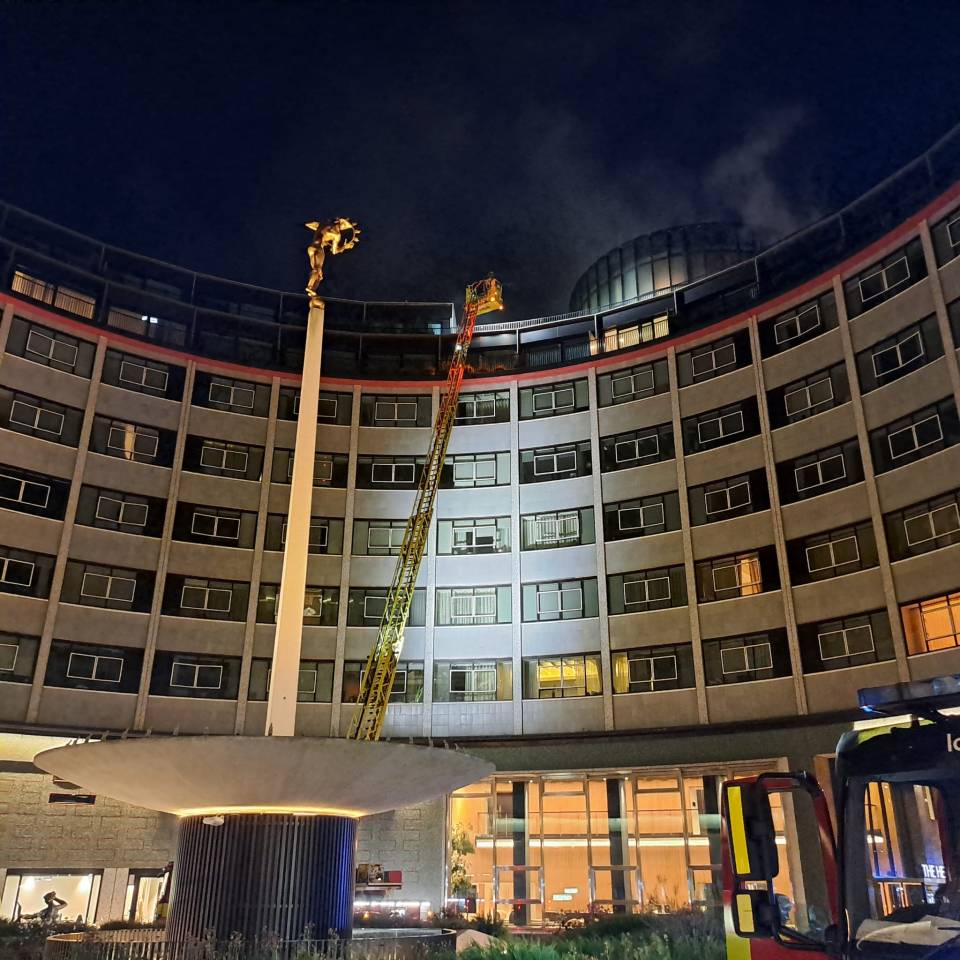 Firefighters battling a blaze at a building at night.