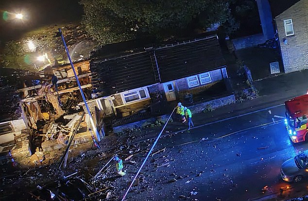 Pictures show the site of the possible gas explosion  - the property has been torn apart with bits of building material covering the street inside the police cordon