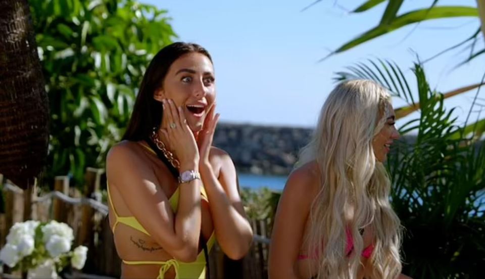 Two women reacting with surprise on a beach.