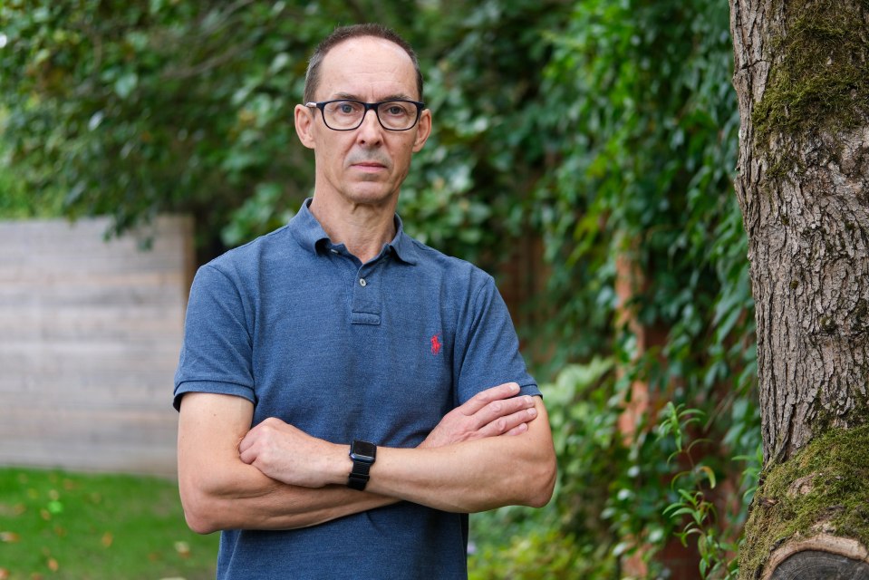 Nick Dawson, author of a book about his brother's murder, stands with arms crossed.