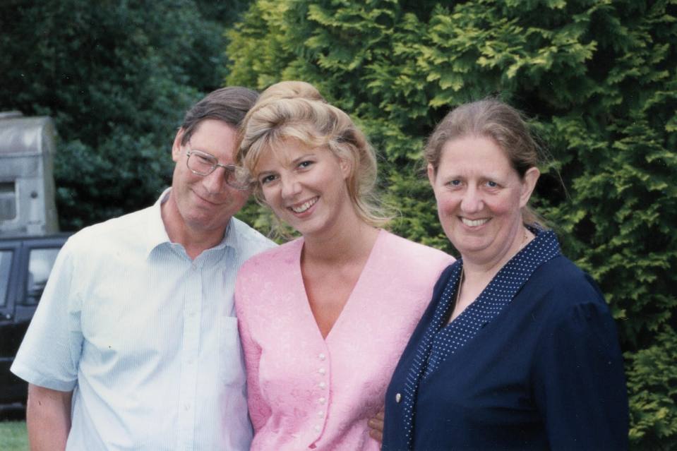 Photo of three people posing together outdoors.