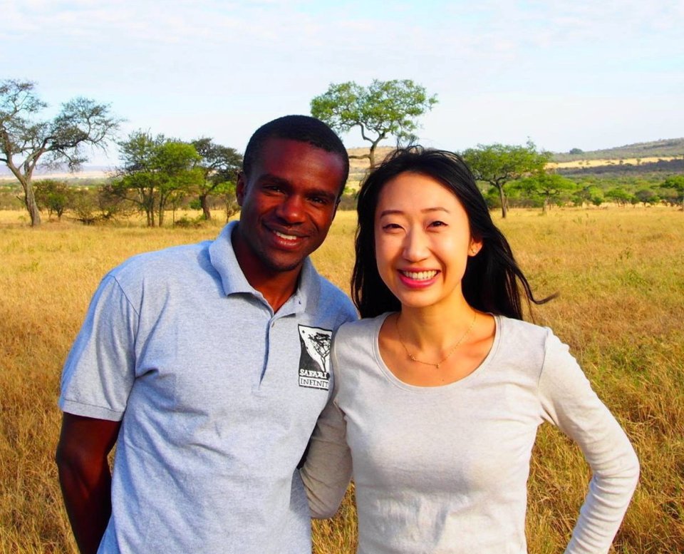 A woman and a man smiling for a photo in an African savanna.