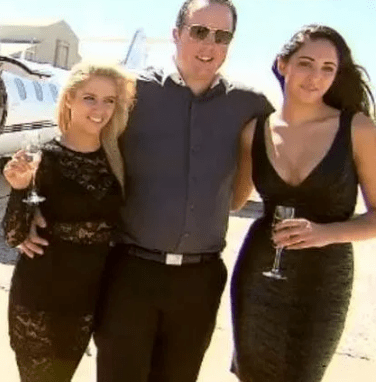Man with two women near a private jet.