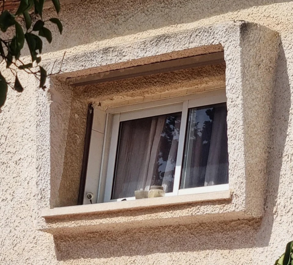 A small security camera is barely visible above the window frame on an outside wall.