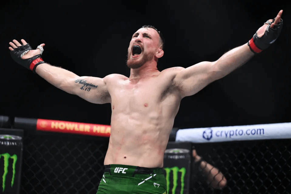 A victorious mixed martial arts fighter with arms raised.
