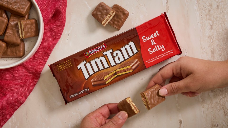 Tim Tam Sweet & Salty biscuits, with one broken in half to show the chocolate filling.