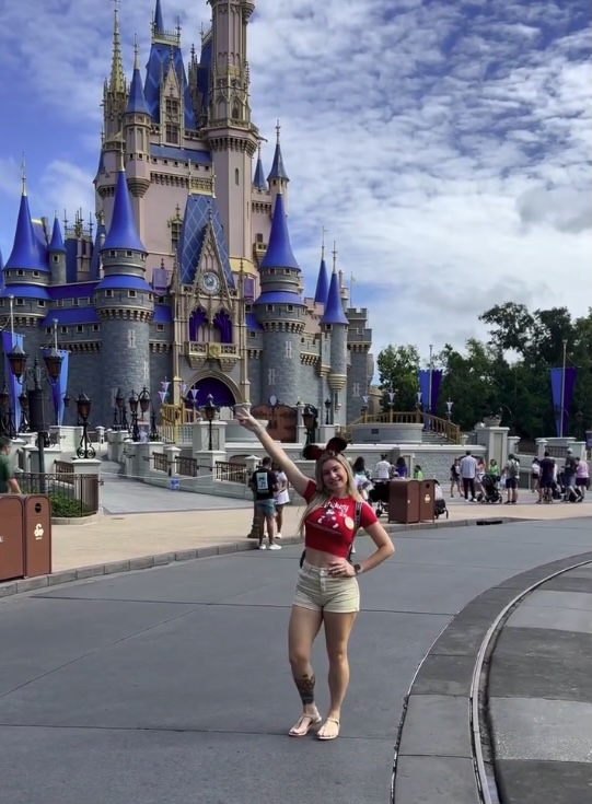 Woman in front of Cinderella Castle at Disney World.