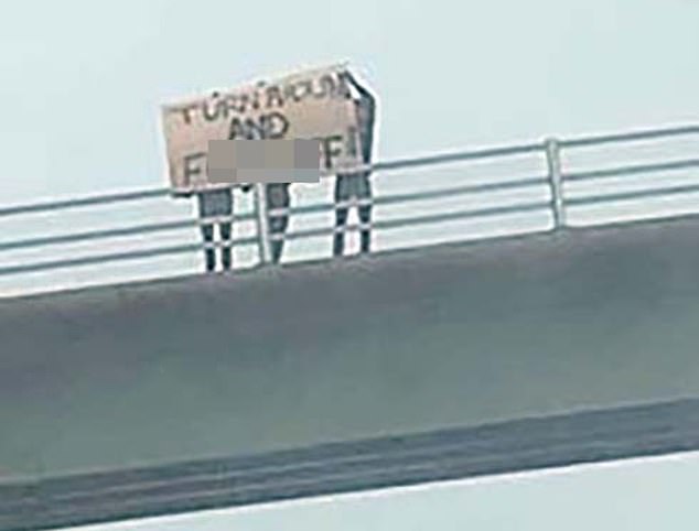 Pictured: A crude 6ft long banner - written in black paint on a white board - was held by three people to welcome tourists to Cornwall