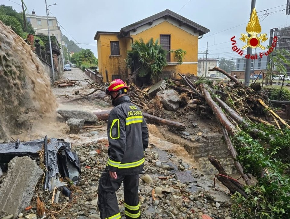 A firefighter surveys a flooded, debris-strewn street in Como, Italy.