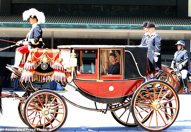Japanese Prince Hisahito, son of Crown Prince Akishino, wearing ancient ceremonial costume, leaves for a ceremony by a carriage at the Imperial Palace in Tokyo on Saturday