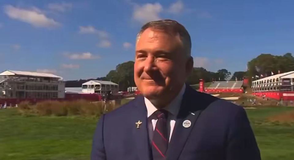 A man in a suit jacket with a PGA pin on his lapel.
